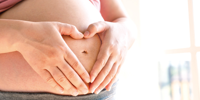 Frauenaerztin-Muehltal-Schwangerenvorsorge-schwangere-Frau-legt-Haende-in-Herzform-auf-den-Bauch-400x200px