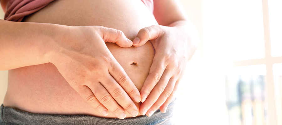 Frauenaerztin-Muehltal-Schwangerenvorsorge-schwangere-Frau-legt-Haende-in-Herzform-auf-den-Bauch-900x400px